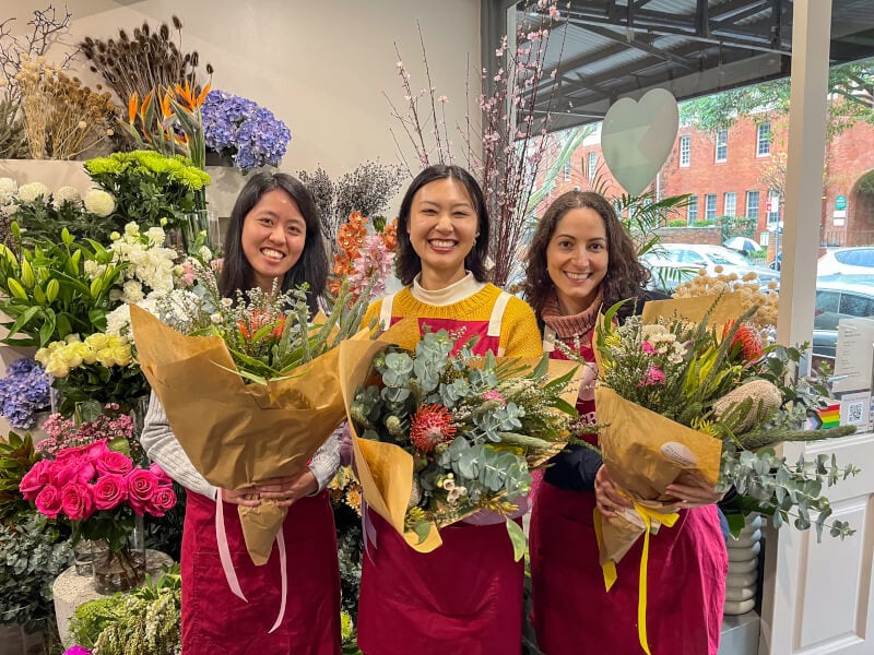 three women at a flower arranging class